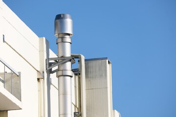 青空を背景にした工場の煙突
