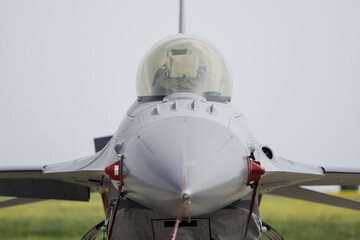 Fighter jet in parking position with red remove before flight ribbon attached