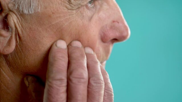 Close-up of an elderly man touching his cheek, toothache and allergy concept. ooth Pain And Dentistry.