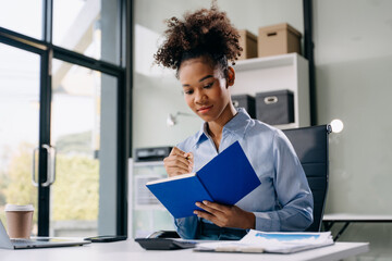 Young beautiful woman using laptop and tablet while sitting at her working place. Concentrated