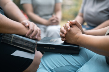 Christian woman held hands with the group, expressing their faith through prayer and devotion to...