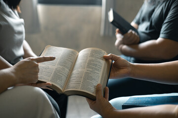 Group of Christian women sat together in chairs, holding their Bibles, feeling the togetherness of...