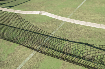 detail of the net of an abandoned and weathered paddle tennis court