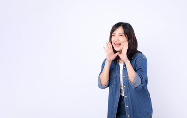Asian woman wearing denim jean is posing with a shouting gesture against a white background.