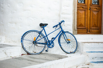a blue old bicycle in the upper traditional city of Patmos with white cycladic houses Greece