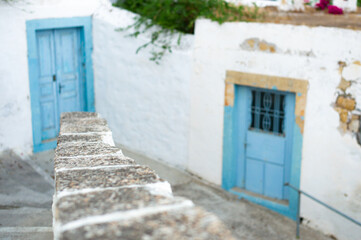 staircases of the traditional upper village with light blue doors and white cycladic houses of the...