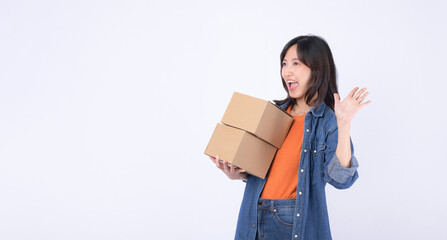 young asian woman wearing orange t-shirt and denim shirt holding parcel box isolated on white studio background, Delivery courier and shipping service concept.