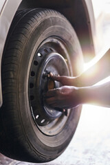 Tyre, hands and mechanic in garage for repairs, rubber and fixing or replace fitting on car at shop. Closeup, person and service or safety check inspection, motor and alignment of vehicle to change