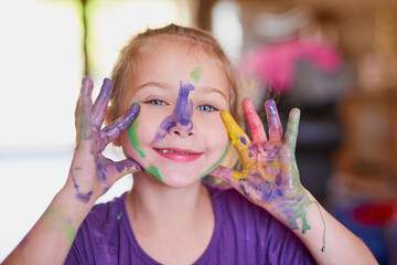 Happy, girl and paint on hands in portrait with fun for creative learning, education and growth...