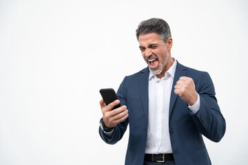 Happy delighted satisfied business man looking at mobile phone screen gesturing yes winning pose,...