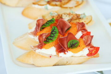 Bruschetta with dried meat and oranges. Delicious gourmet appetizers for the banquet. Catering.