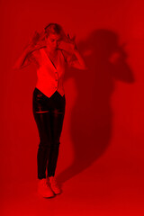 Slender blonde woman in red light
