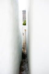 gap between two traditional white cycladic houses in the upper city of patmos island Greece