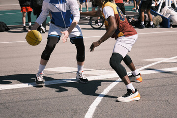Men play street basketball on the asphalt in the city.