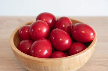 Red painted eggs in a wooden bowl