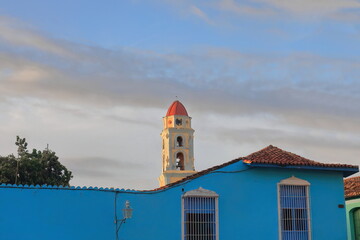 The Iglesia de San Francisco de Asis Church belfry seen over a blue colonial house on the Plaza...