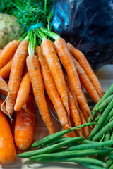 Bunch on fresh orange carrots with green on wooden box