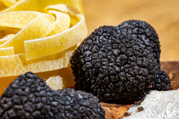 Cooking pasta with Italian black summer truffle, tasty aromatic mushroom, close up
