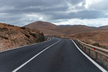 Mountain road on colourful remote basal hills and mountains of Massif of Betancuria, Fuerteventura,...