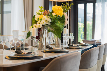 close up of nice dining chair with wooden table and dish sets interior design vintage color tone with light flare ,beautiful table setting for wedding or other celebration home design