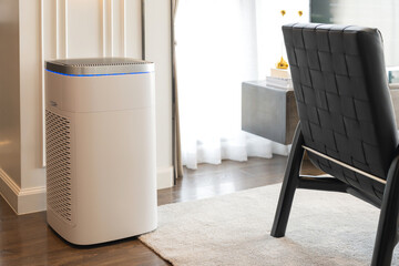 Air purifier in the room. Air washing system Air purifier in living room, dust protection sofa in background