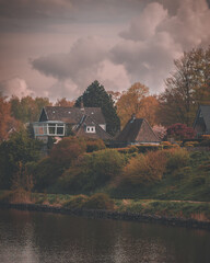 photograph of houses from the water side in autumn style