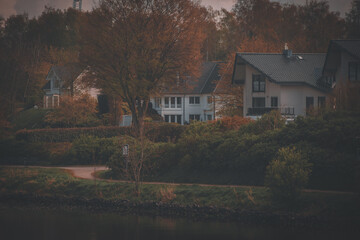 Obraz premium photograph of houses from the water side in autumn style