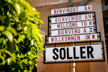 At Sóller train station a multilingual welcome sign greets tourists in five languages (Catalan, Spanish, English, French, German), warm greetings to visitors arriving in Mallorca destination Sóller.