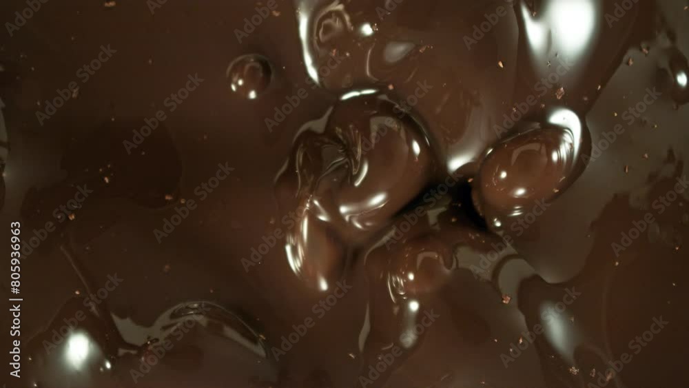 Poster Super Slow Motion of Falling Group of Chocolate Chunks. Moving Down and Splashing into Melted Chocolate. Filmed on High Speed Cinema Camera, 1000fps. Speed Ramp Effect.