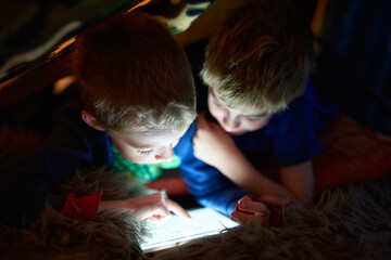 Home, children and brothers on tablet in tent for game, movie or streaming cartoon online at night...