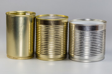 Different open empty white and yellow tin cans, side view
