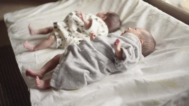 Twin male and female babe crying while moving their arms and legs (2)