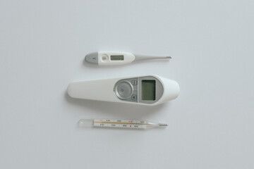 Comparison of mercury thermometer, infrared and electronic thermometer baby thermometer for measuring human body temperature on light background. Types of thermometers. Copy space