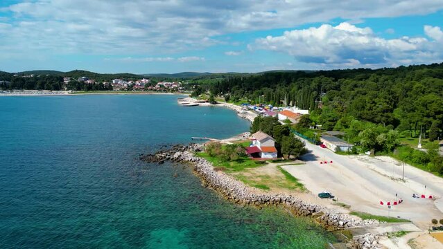 In the vicinity of Rovinj and Camp Valalta in Istria, Croatia, the landscape is characterized by scenic fields, bicycle roads, and lush greenery captured by drone