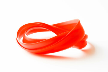 A bright red rubber band, stretched and twisted into an interesting shape, resting on a stark white background.