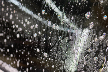 Closeup of windshield with water drops, showing moisture on auto part