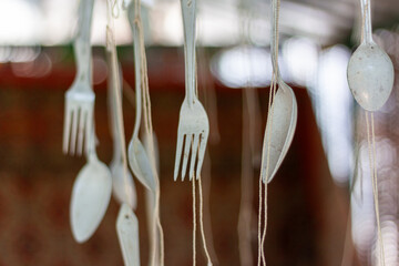 A captivating display of hanging forks and spoons against a blurred background