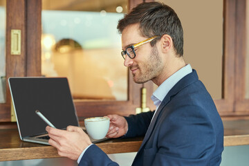 Businessman, laptop and phone in cafe with glasses for remote work with reading sms, work break and...