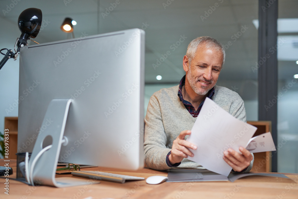 Poster Mature man, reading and documents with computer in office, table and smile for report of sales and profit. Company, finance and paperwork for accounting, budget and pc for investment of business