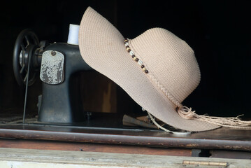 Industrial Elegance: The Hat Adorning the Sewing Machine