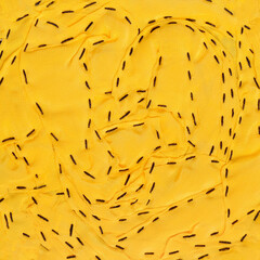 Abstract yellow textile background texture with black lowercase stitches.