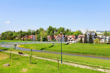 NOWY TARG, POLAND - MAY 27, 2023: Boulevards on the Dunajec River in Nowy Targ. Charming estates of...
