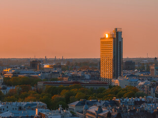 Naklejka premium Aerial panoramic sunset over Riga old town in Latvia. Beautiful spring sunset over Riga. Golden hour fire sunset.