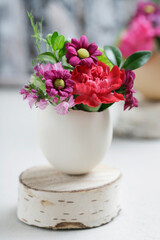 Florist at work: woman shows how to make simple Easter decoration with egg shell and various flowers. Step by step, tutorial.