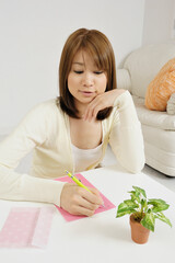 直筆で手紙を書く若い日本人女性