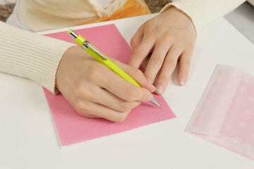 手紙を書く若い女性の手