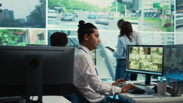 Indian worker operating on license plate registration via CCTV radar footage, working with video surveillance system in real time. Government employee monitoring traffic. Camera B.