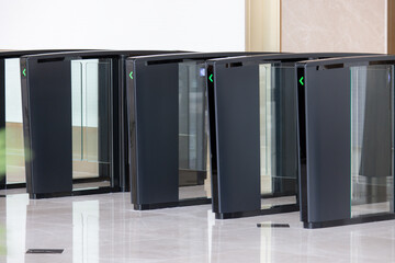 A row of black and glass doors with green lights