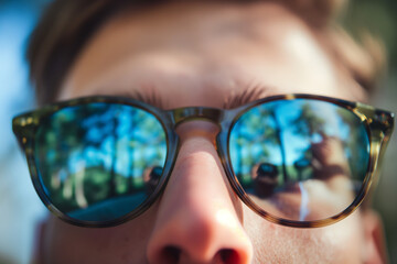 close up of a person wearing brown plastic framed glasses
