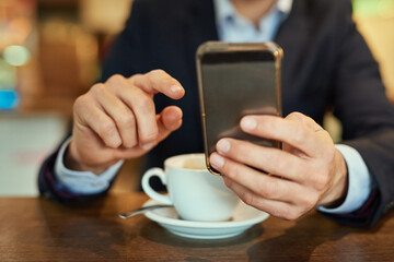 Businessman, smartphone and coffee to relax in cafe for online search, browse internet or reading communication. Male person, cup and mobile technology in shop to scroll, post or update social media